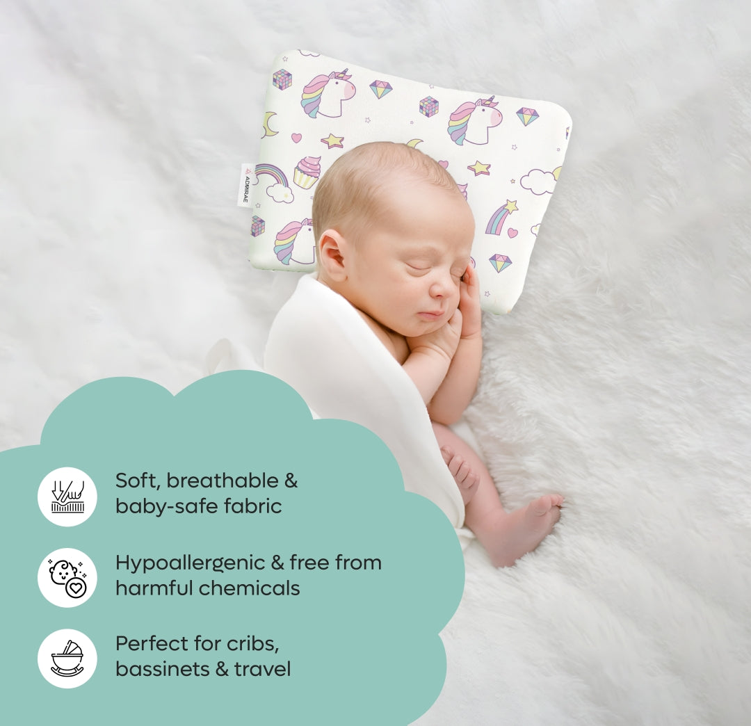 Sleeping baby using ADMIRAE Head Shaping Baby Pillow with unicorn design on soft white surface