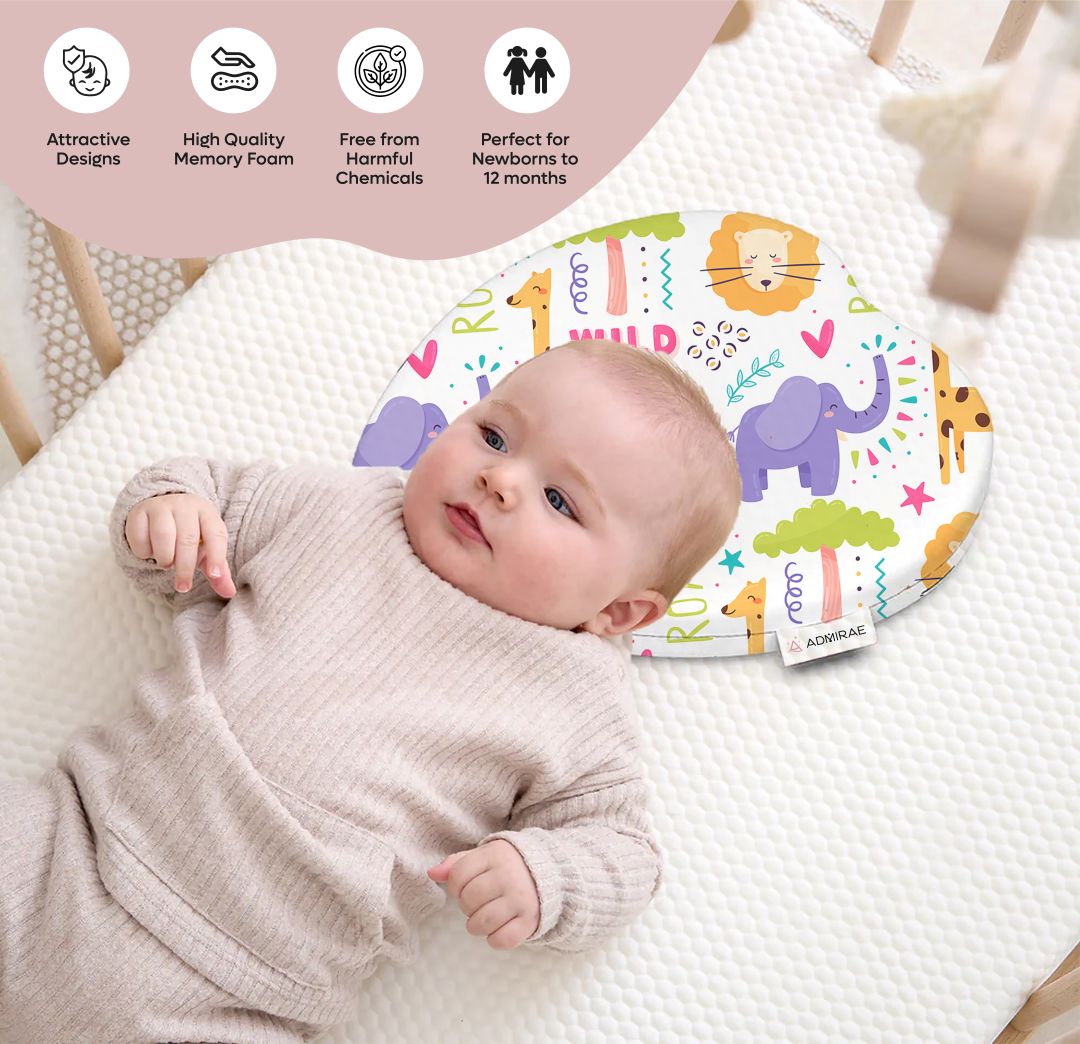 ADMIRAE Head shaping heart Baby Pillow with colorful animal prints supporting a newborn lying on a white textured mattress