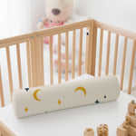 ADMIRAE baby bolster pillow with moon and star patterns placed in a wooden crib for infant comfort
