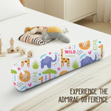 ADMIRAE baby bolster pillow with colorful wild animal prints including elephants, lions, and giraffes on a white bed