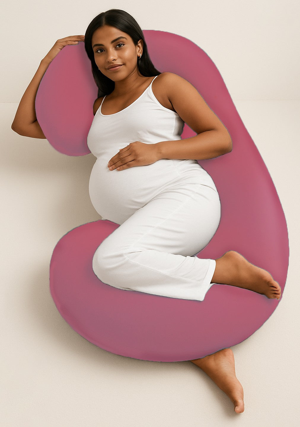 Pregnant woman lying comfortably with ADMIRAE C shape pregnancy pillow in pink for full body support