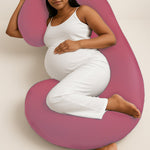 Pregnant woman lying comfortably with ADMIRAE C shape pregnancy pillow in pink for full body support