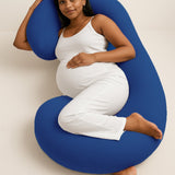Pregnant woman resting comfortably with Admirae C shape pregnancy pillow in blue for full body support